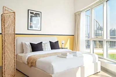 a bedroom with a bed and a large window at Silkhaus Chic Studio at Barsha Heights in Madison in Dubai