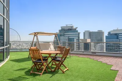 a patio with a table and chairs on a roof at Silkhaus Cozy Studio at Madison in Barsha Heights in Dubai