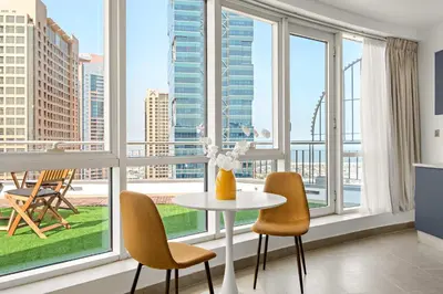 a living room with a table and chairs and windows at Silkhaus Large Studio in Madison near Barsha Heights in Dubai