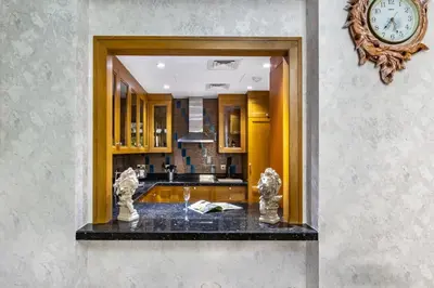 a kitchen with a clock on the wall and a counter at Stylish 2-Bedroom in the Heart of OldTown Dubai in Dubai