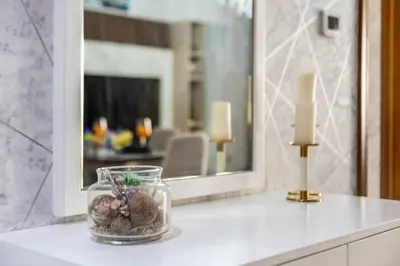 a bathroom counter with a glass jar with seashells and candles at Stylish 2-Bedroom in the Heart of OldTown Dubai in Dubai