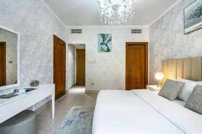 a bedroom with a white bed and a chandelier at Stylish 2-Bedroom in the Heart of OldTown Dubai in Dubai