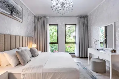 a bedroom with a large white bed and a chandelier at Stylish 2-Bedroom in the Heart of OldTown Dubai in Dubai