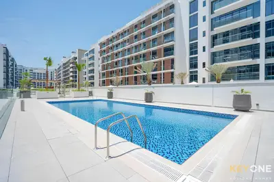 a swimming pool in front of a building at Modern Elegance Studio in Azizi Riviera in Dubai