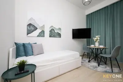 a white room with a bed and a table at Modern Elegance Studio in Azizi Riviera in Dubai