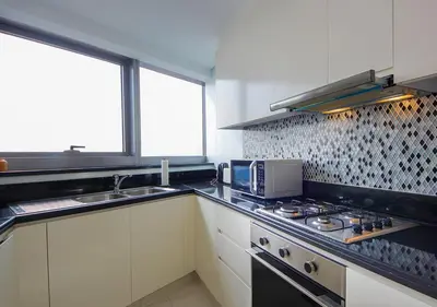 a kitchen with a stove and a sink and a microwave at Opulent 2BR In Paramount Hotel Apt in Dubai
