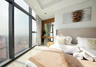 a bedroom with a large bed and large windows at Opulent 2BR In Paramount Hotel Apt in Dubai