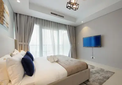 a bedroom with a large bed with a tv on the wall at Opulent 2BR In Paramount Hotel Apt in Dubai