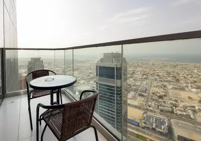 a balcony with a table and chairs and a city at Opulent 2BR In Paramount Hotel Apt in Dubai