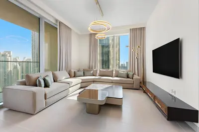 a living room with a couch and a tv at Forte Tower 1 in Dubai