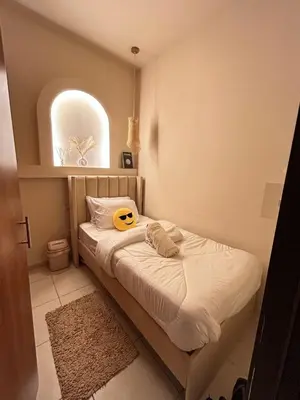 a small bedroom with a bed with a yellow helmet on it at Adaz Home in Dubai