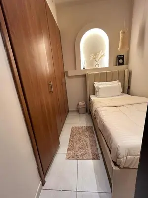 a small bedroom with a bed and a window at Adaz Home in Dubai