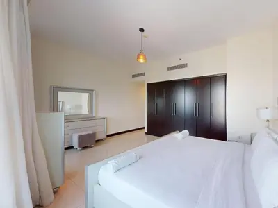 a bedroom with a white bed and a couch at Spacious Duplex 4BR with Maids Room in Dubai