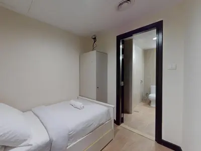 a bedroom with a white bed and a bathroom at Spacious Duplex 4BR with Maids Room in Dubai