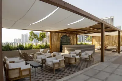 a patio with a white canopy and chairs and tables at Modern Studio at Upside Living with Burj Views - Business Travelers in Dubai