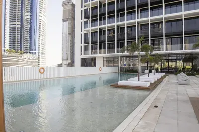 a swimming pool in front of a building with tall buildings at Modern Studio at Upside Living with Burj Views - Business Travelers in Dubai
