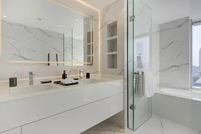 a white bathroom with a sink and a shower at Luxurious Apartment And Amazing Dubai Marina View in Dubai