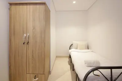a bedroom with a bed and a wooden cabinet at Luxury 2BHK Plus Maid's Room The Sterling West Near Dubai Mall in Dubai