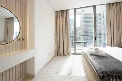 a bedroom with a bed with a mirror and a window at Luxury 2BHK Plus Maid's Room The Sterling West Near Dubai Mall in Dubai