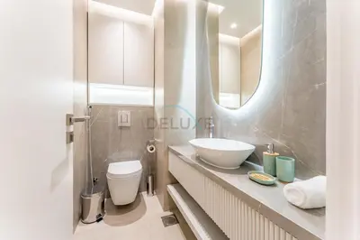 a bathroom with a sink and a toilet and a mirror at Renovated 1BR with Partial Sea and City Views Close to the Beach, Elite Residence, Dubai Marina by Deluxe Holiday Homes in Dubai