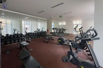 a gym with rows of exercise bikes and treadmills at Luxurious 2-Bedroom Haven in Dubai