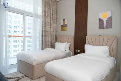 two beds in a hotel room with a window at Luxurious 2-Bedroom Haven in Dubai