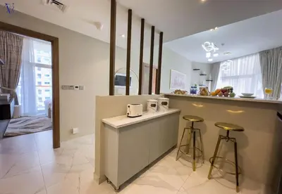 a kitchen with two bar stools and a counter at Luxurious 2-Bedroom Haven in Dubai