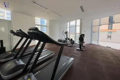 a gym with treadmills and cardio equipment in a room at Luxurious 2-Bedroom Haven in Dubai