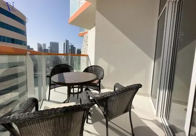 a balcony with chairs and a table on a building at Luxurious 2-Bedroom Haven in Dubai