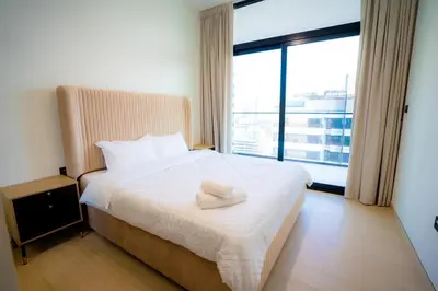 a bedroom with a white bed with a large window at Luxury 2 bedroom Unit, Prime Location in Dubai