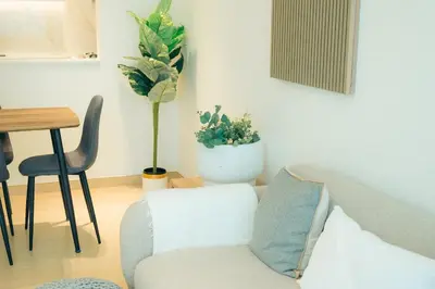 a living room with a couch and two potted plants at Luxury 2 bedroom Unit, Prime Location in Dubai