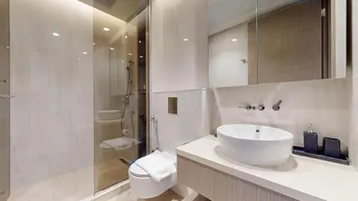 a bathroom with a sink and a toilet and a shower at Peninsula - Modern Two Bedroom in Business Bay in Dubai