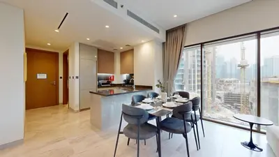 a kitchen and living room with a table and chairs at Peninsula - Modern Two Bedroom in Business Bay in Dubai