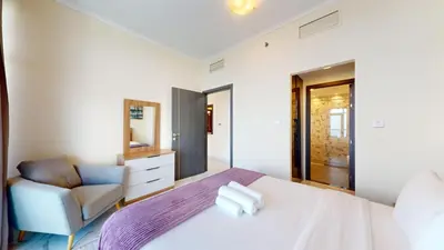 a bedroom with a white bed and a chair at Torch Tower - One Bed with Skyline View in Marina in Dubai
