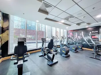 a gym with cardio equipment and a large window at Torch Tower - One Bed with Skyline View in Marina in Dubai