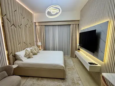 a bedroom with a bed and a flat screen tv at Meydan Riviera Midtown Comfort Studio in Dubai