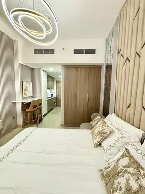 a bedroom with a large white bed with a chandelier at Meydan Riviera Midtown Comfort Studio in Dubai