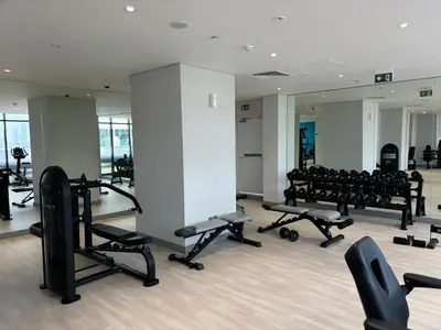 a gym with several rows of treadmills and weights at Meydan Riviera Midtown Comfort Studio in Dubai