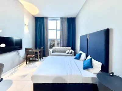 a hotel room with a large bed and a chair at Al Manara Classic Luxe Studio in Dubai