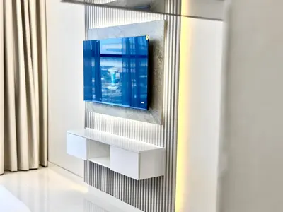 a tv hanging on a wall in a room at Al Manara Premium Lux Studio in Dubai