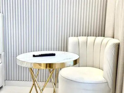 a table and a chair with a remote control on it at Al Manara Premium Lux Studio in Dubai