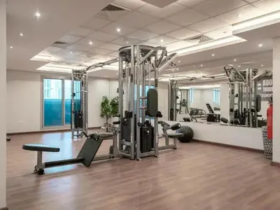 a gym with treadmills and machines in a room at Chic Studio with Balcony a mins drive to Downtown in Dubai