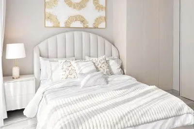 a white bedroom with a large white bed with pillows at 1 Bedroom Marina with Canal View in Dubai