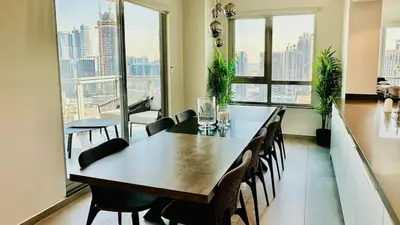 a dining room with a table and chairs and windows at Ultimate 5BR Luxury I 2500 sqf I Burj Inner Circle in Dubai