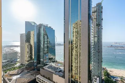 a view of a city with tall buildings and the ocean at Bright and Spacious 2BR with Pool and Gym Access in Dubai