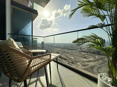 a balcony with chairs and a view of the city at Trophy-Brandnew Premium and Vibrant 1BR in JVC in Dubai
