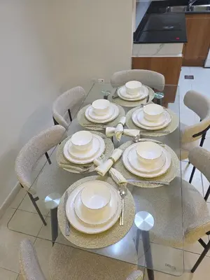 a glass table with chairs and plates on it at 28- Luxury Princess Tower Marina Apartment with Sea View, Pool & Balcony in Dubai