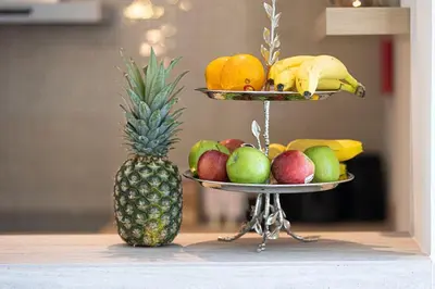 a plate of fruit on a table with a pineapple at Mahogany 4 - 2BR 6PAX - Panoramic Burj Khalifa View in Dubai
