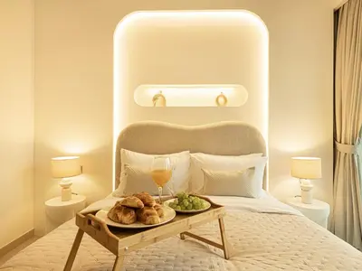 a bed with a tray of bread and wine glasses at Burj Royale Suites by Prestige Nest in Dubai