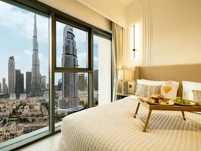 a bedroom with a bed with a view of a city at Burj Royale Suites by Prestige Nest in Dubai